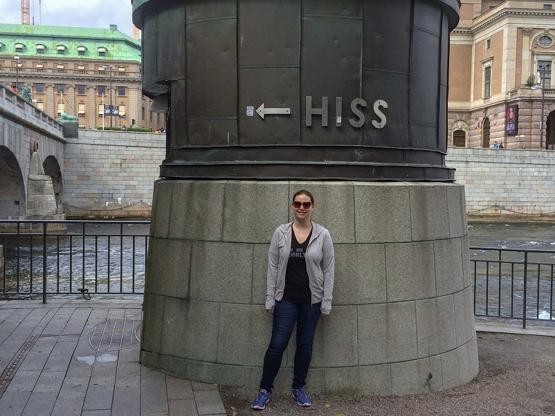 Woman traveling with a lung disease standing in front of a sign that says "HISS", Swedish for elevator