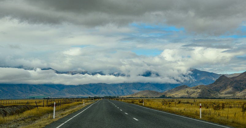 Cloudy sky over an open road on the seen driving between Arrowntown, Wanaka, and Twizel in New Zealand