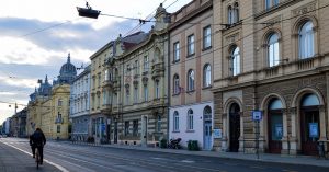 A man biking on a street at dusk in Zagreb, Croatia