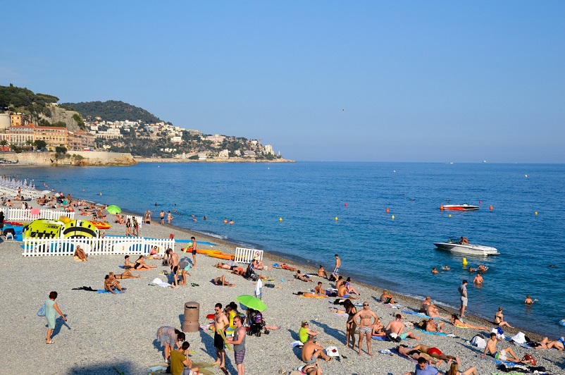 People relaxing on the beach and in the ocean in Nice, France