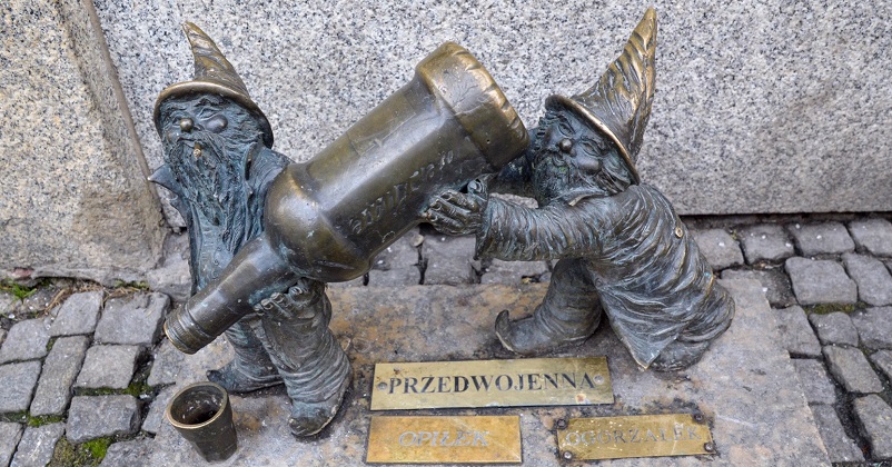 Two Wroclaw gnomes with a bottle of liquor