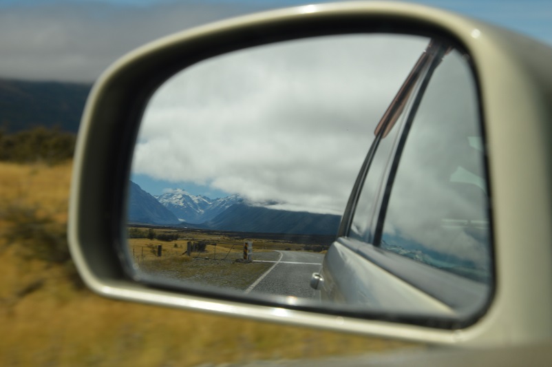 Rearview mirror showing New Zealand landscape