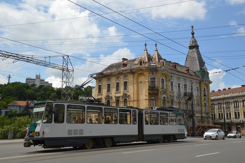 Tram in front of a yellow building in Cluj; public transport in Romania
