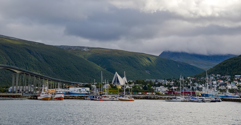 Harbor with boats surrounded by mountains in Tromso, Norway