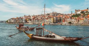 Two boats in the river in front of view of buildings in Porto, Portugal