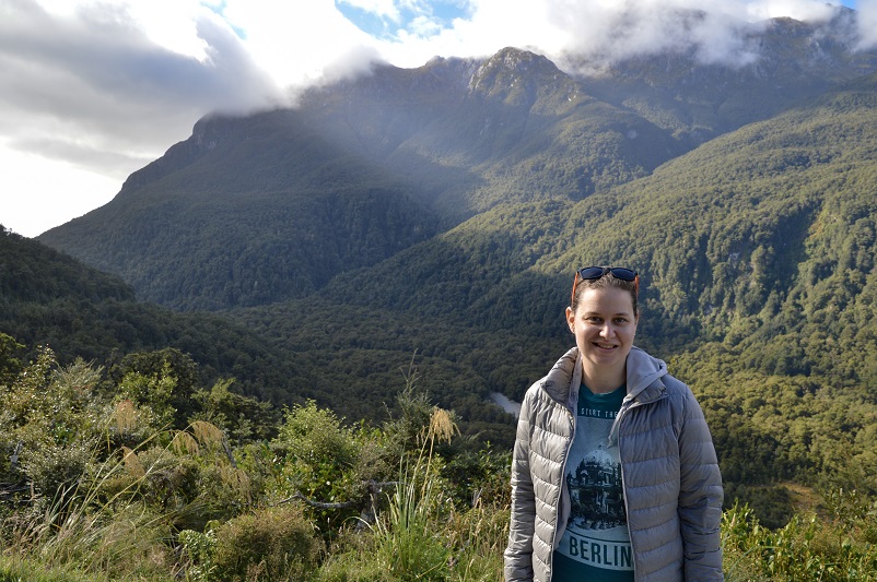 Woman standing in front of mountains in Fiordland in New Zealand