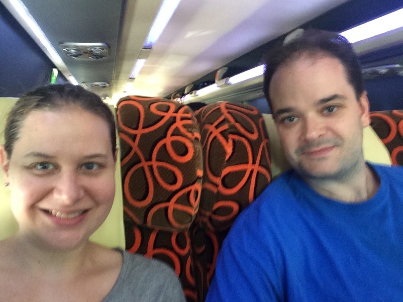Sarah and Justin smiling on the Kuala Lumpur to Singapore bus