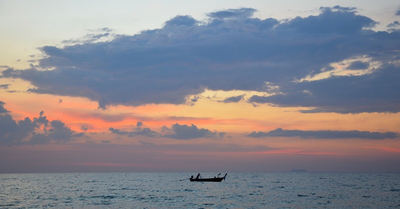 Small boat on the water at sunset in Koh Lanta, Thailand