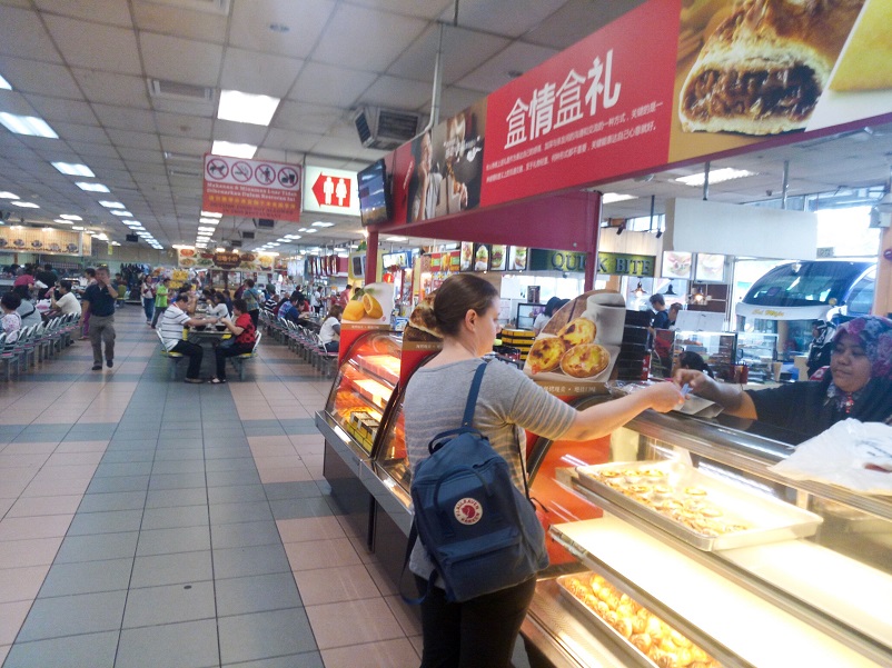 Sarah buying snacks in the hawker center on the bus trip from Kuala Lumpur to Singapore