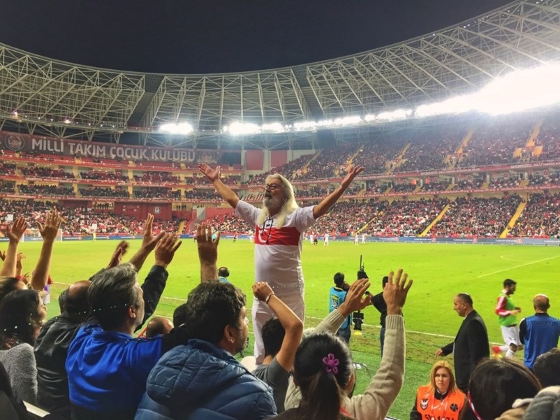 Fans cheering, led by one man, at a Turkish national team football match