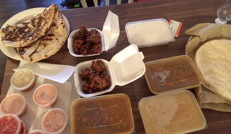 Table of curry, fritters, naan, rice and side dishes in Glasgow, Scotland