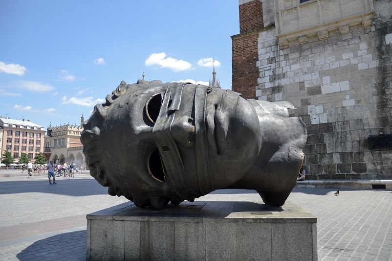 A sculpture of a large head on its side in Krakow, Poland