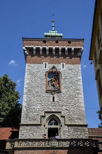 An old looking rectangular tower against a blue sky, Florian’s Gate in Krakow