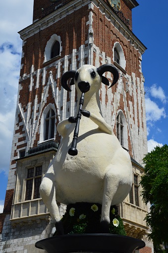 Sculpture of a white goat playing a lute in Krakow