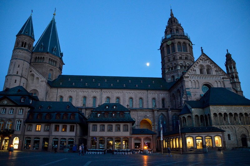 Large pink cathedral against an evening sky with the moon in the background; Mainz Cathedral, Germany