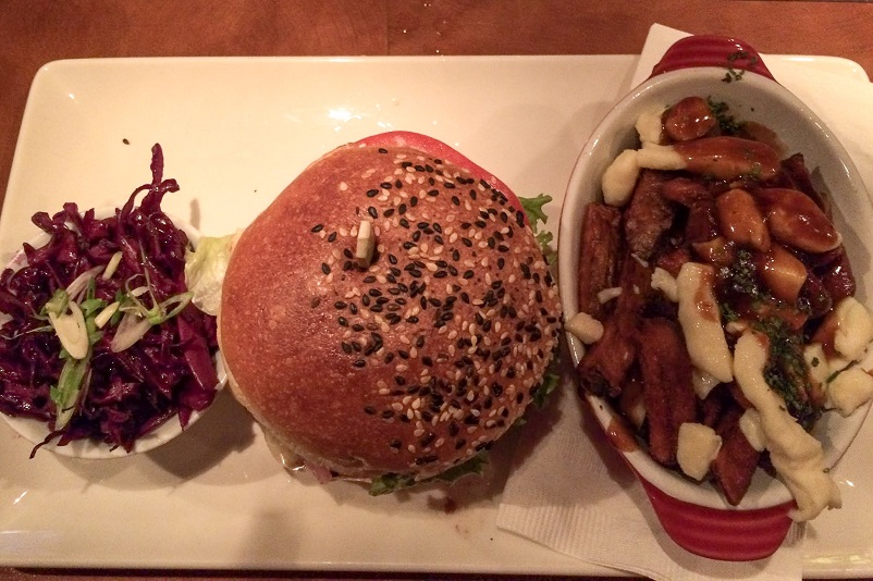 Plate of a salad, burger, and poutine in Montreal, Canada