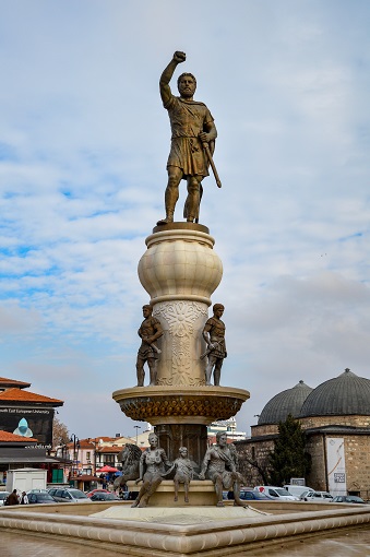 Very tall monument featuring a large man raising his arm at the top and other figures beneath, Philip II monument in Skopje
