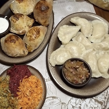 Two plates of pierogis and one salad in Wroclaw, Poland