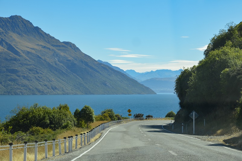 A curving road with a lake and mountains in the distance: Devil's Highway in New Zealand