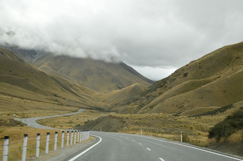 Winding road surrounded by mossy green hills from Wanaka to Twizel