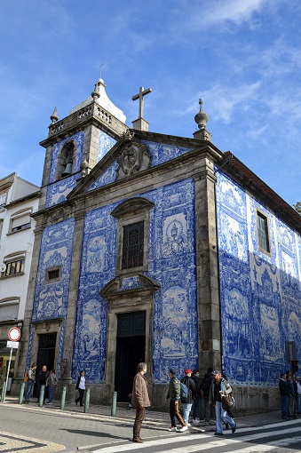 Facade of the Chapel of Souls decorated with blue and white azulejo tiles in Porto
