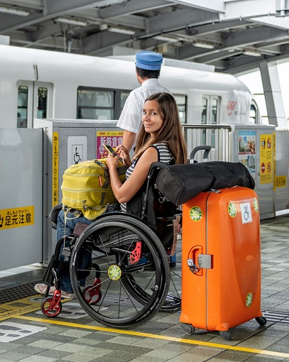 Melanie in her wheelchair waiting to board the tram in Okinawa, Japan