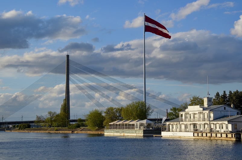 Large Latvian flag in front of the modern Vansu Bridge in Riga