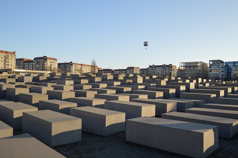 Concrete blocks of the Holocaust Memorial with a hot air balloon floating in the sky in the background in Berlin