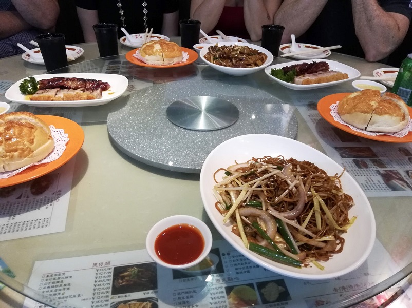 Numerous dishes on a lazy susan eaten on a Shanghai food tour