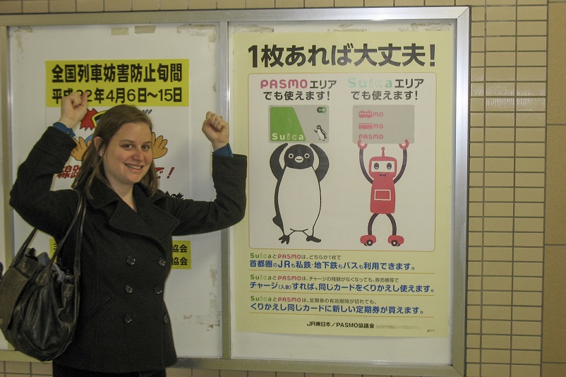 Sarah imitating the Pasmo and Suica characters in a sign in Tokyo, Japan