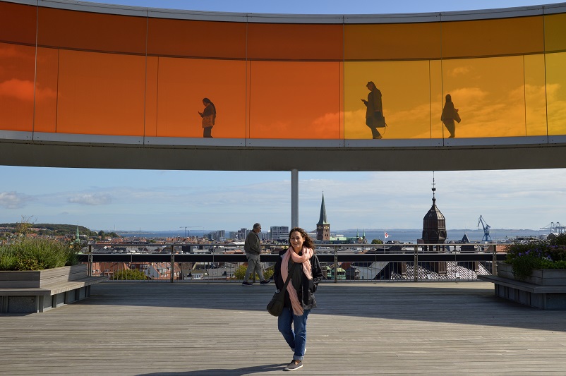Woman standing underneath the ARoS rainbow panorama, one of the Aarhus museums