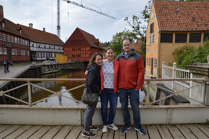 Three people standing in front of water at Den Gamle By in Aarhus