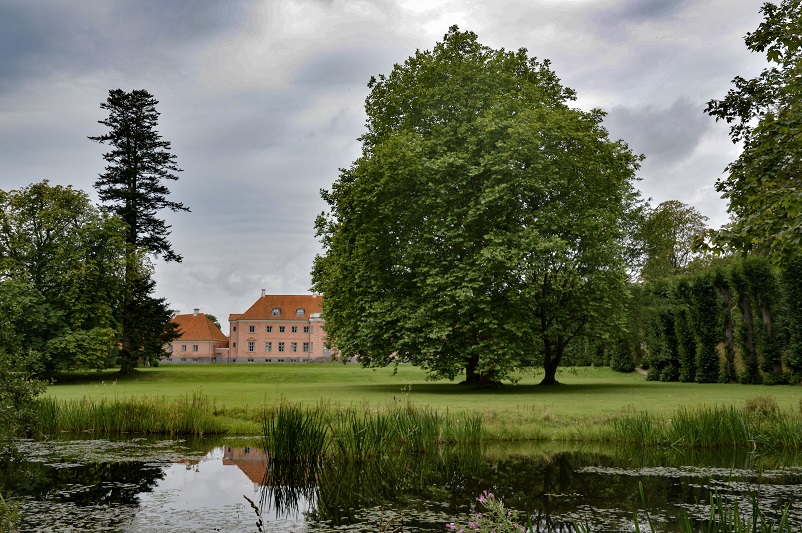 Pink building behind water and trees near the Moesgaard Museum near Aarhus, Denmark