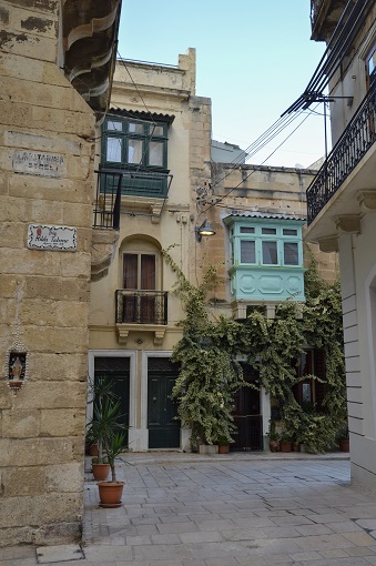 Facades of buildings, one covered in ivy, in Birgu, Malta