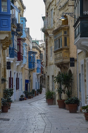 Winding street with blue balconies in Birgu, Malta