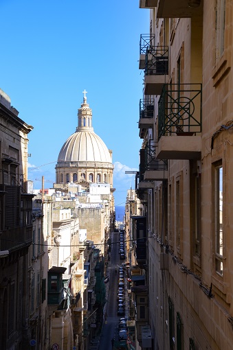 Madonna tal-Karmnu church seen down a shadowy street in Valletta, Malta