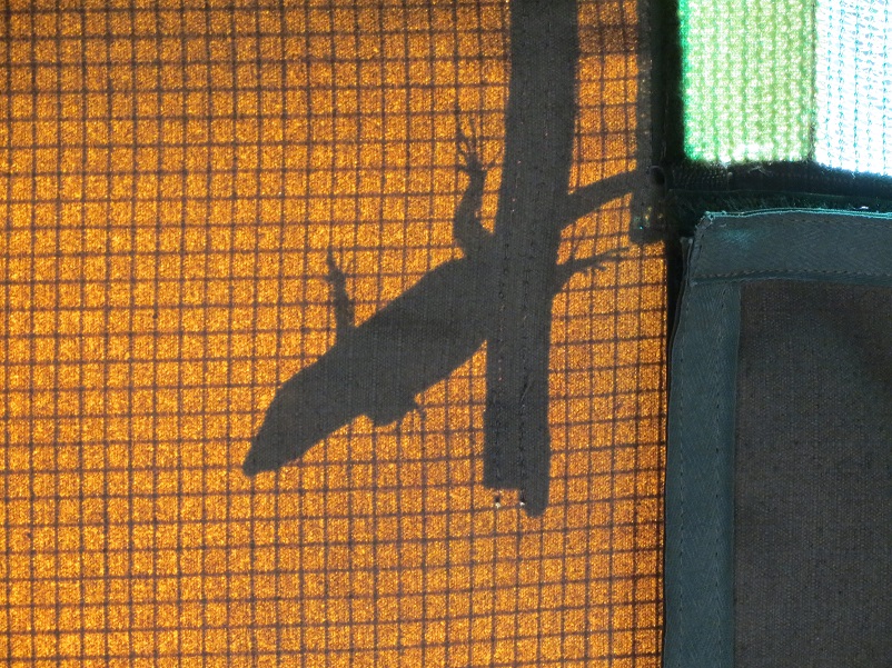 Shadow of a gecko outside an orange tent in Botswana