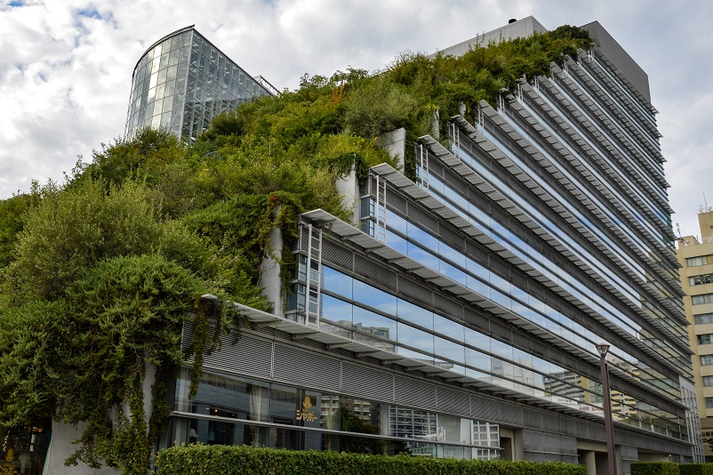 Modern stepped building with glass windows and trees growing on it: ACROS in Fukuoka