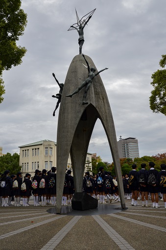 School children surrounding memorial sculpture in Hiroshima Peace Memorial Park