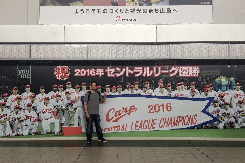Justin standing in front of a sign that says: "Carp 2016 Central League Champions"