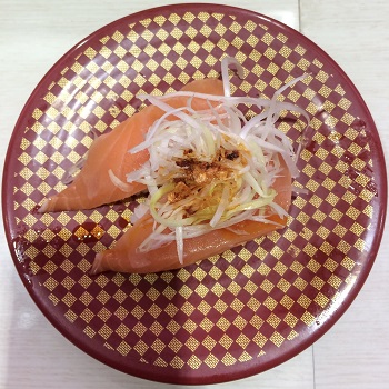 Two pieces of tuna sushi with a spicy radish topping on a plate at Uobei in Tokyo