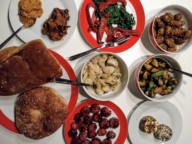 8 plates and bowls of Maltese foods on a table in Valletta