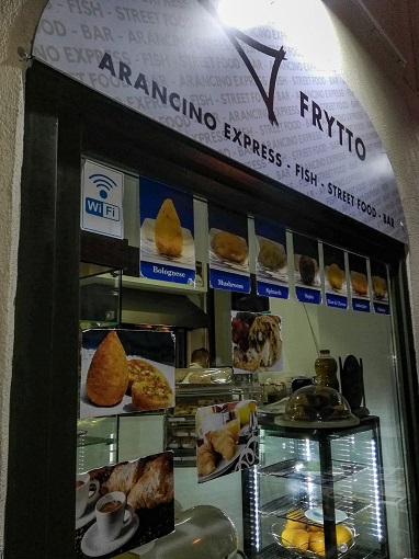 Window showing signs with aracini balls at a snack shop in Valletta