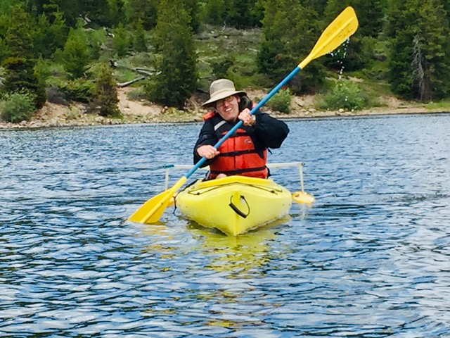 Man smiling in a yellow kayak