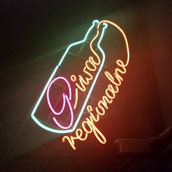 Neon sign of a beer bottle at Absurdalna bar in Katowice
