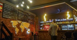 A man looking at the tap list of craft beer in Katowice at Biała Małpa