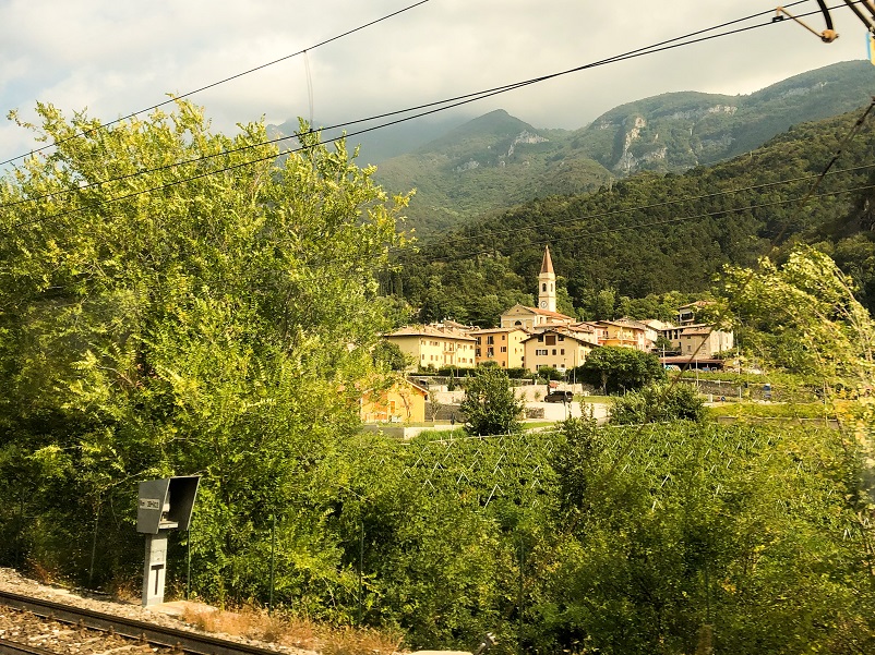 Small buildings and moutains seen in out the window from the Innsbruck to Bologna train