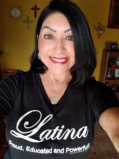 Maria, a woman, wearing a shirt that says "Latina: proud, educated, and powerful"