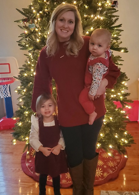 Meagan (a woman with LAM) holding her two daughters in front of a Christmas tree