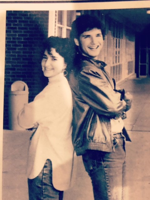 An old, sepia toned picture of Sarah and her brother standing back to back